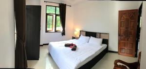 a bedroom with a bed with a teddy bear on it at Orchid Pool -Villa 3 bedrooms in Ko Lanta