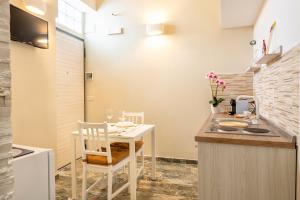 una cucina con tavolo e sedie bianchi in una stanza di Sg Apartment Luxury a Massafra