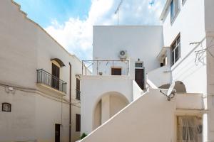 un vicolo tra due edifici bianchi di Sg Apartment Luxury a Massafra