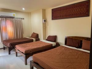 a room with three beds in a room at Bansuan Inthanon resort -Classic House in Chom Thong