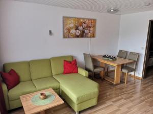 sala de estar con sofá verde y mesa en B5 Schwarzwald-Fewo an der Alb, en Menzenschwand