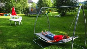 a woman laying on a swing in a park at B5 Schwarzwald-Fewo an der Alb in Menzenschwand