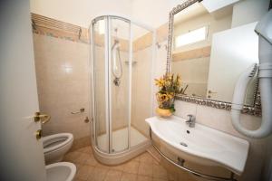 リッチョーネにあるHotel Cristinaのバスルーム(シャワー、洗面台、トイレ付)