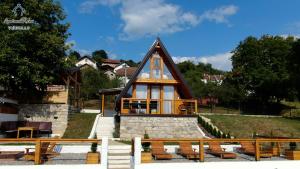 ein kleines Haus mit einer Gruppe Bänken davor in der Unterkunft Apartmani Relax in Višegrad