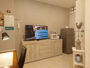 uma televisão em cima de uma cómoda com um micro-ondas em ROOMS PIAZZETTA LA MADDALENA 2 em Savona