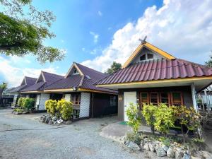 una fila de casas con techos morados en Bansuan Inthanon resort -Classic House en Chom Thong