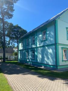Majori Guesthouse في يورمالا: بيت ابيض وزرق مع مبنى