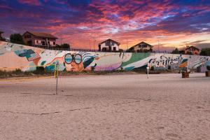 een muur met graffiti erop met een zonsondergang bij Sunrise by the Sea in Constanţa