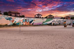 a wall with graffiti on it with a sunset at Sunrise by the Sea in Constanţa