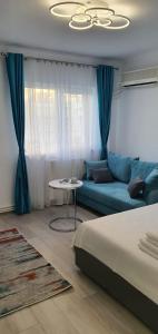 a living room with a blue couch and a table at Sunrise by the Sea in Constanţa
