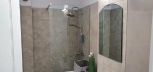 a bathroom with a shower with a mirror and a sink at Sunrise by the Sea in Constanţa +18 photos