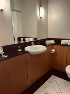 W łazience znajduje się umywalka, lustro i toaleta. w obiekcie The Terrace Hotel w mieście Magherafelt