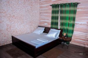 ein kleines Bett in einem Zimmer mit Fenster in der Unterkunft RESIDENCE AINA in Abomey-Calavi