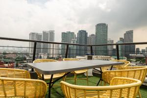 un tavolo e sedie su un balcone con vista sullo skyline della città di Z Hostel a Manila