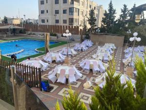 a pool with white lounge chairs and a swimming pool at Casablanca Hotel Ramallah in Ramallah