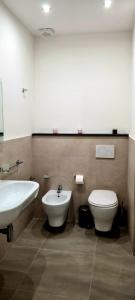 a bathroom with a toilet and a bidet and a sink at Home De Curtis in Catania