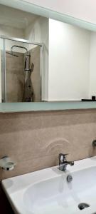 a bathroom sink with a mirror and a shower at Home De Curtis in Catania