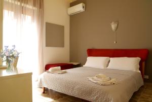 a bedroom with a bed with a red headboard at Night & Day in Ragusa