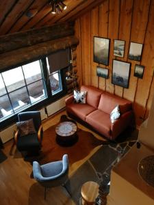 ein Wohnzimmer mit einem Sofa und einigen Stühlen in der Unterkunft Chill Cave - logwood cottage in Ruka