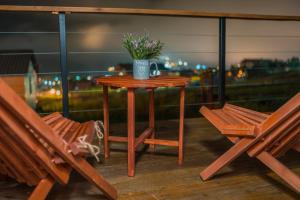 stół z doniczką na balkonie z dwoma ławkami w obiekcie Kazbegi Glamping w mieście Stepancminda