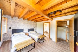 a bedroom with three beds and wooden ceilings at LAGA Surf VILLA by Urdaibai Rentals in Ibarrangelu