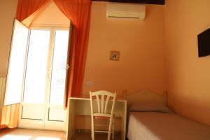 una camera con letto, scrivania e sedia di Night & Day a Ragusa
