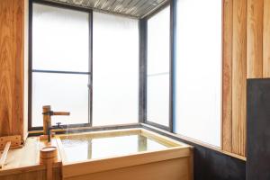 宫若市宮若温泉郷 宮若虎の湯 Miyawaka Toranoyu的带浴缸的窗户客房 更多26张照片