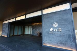 宫若市宮若温泉郷 宮若虎の湯 Miyawaka Toranoyu的侧面有标志的建筑物