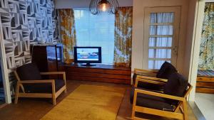 SäkyläにあるPunavilla majoitus TASANKOのリビングルーム(椅子2脚、テレビ、窓付)