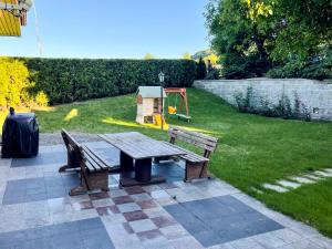 una mesa de picnic y dos bancos en un patio en Dom na Poniatowie, en Wałbrzych