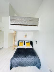 uma cama num quarto branco com almofadas amarelas em aday - Harbor Groundfloor Own Entrance - Studio em Aalborg