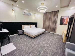 um quarto de hotel com uma cama e uma secretária em Falcon Grand Hotel em Al Hadd