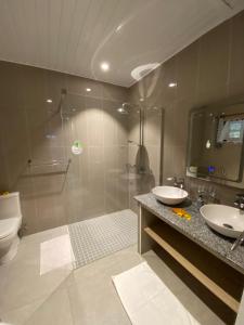a bathroom with a shower and two sinks and a toilet at Coin D'or in Praslin