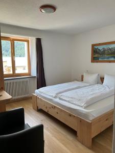 ein Schlafzimmer mit einem Holzbett in einem Zimmer in der Unterkunft Hotel Adler Garni in Zernez