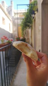 a person holding a piece of food in their hand at Le Altezze in Erice