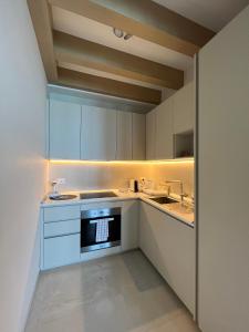 a kitchen with white cabinets and a sink and a stove at Luxury Loft on the Sea in Trapani