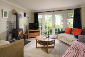 a living room with a couch and a wood stove at Pump Cottage and Annexe, Gwithian in Gwithian