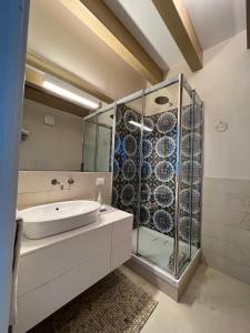 a bathroom with a sink and a glass shower at Luxury Loft on the Sea in Trapani