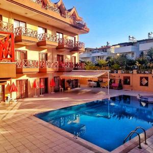 a hotel with a swimming pool in front of a building at HİMEROS BEACH HOTEL in Kemer