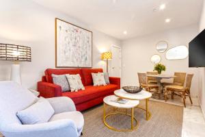ein Wohnzimmer mit einem roten Sofa und einem Tisch in der Unterkunft Genteel Home Constitución in Sevilla