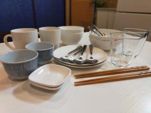 a table with plates and utensils on a table at 龍馬坂荘：1日1組限定・東山清水のてっぺんの小さなお宿、わんこと一緒に。 in Kyoto