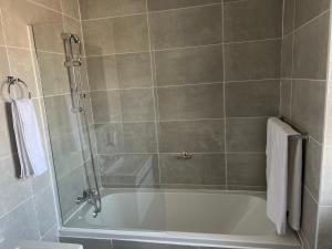 a bathroom with a bath tub with a shower at Sarona City L203 in Gaborone