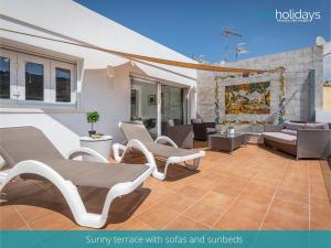 eine Terrasse mit Stühlen, Sofas und einem Gemälde in der Unterkunft Penthouse Guatipiti - HMR Holidays in Rada de Moraira
