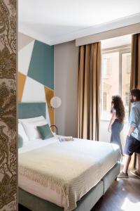 two people standing in a bedroom looking out the window at Boutique Hotel Galatea in Rome