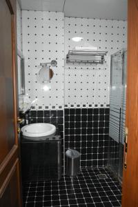 ein Bad mit einer schwarz-weißen Wand in der Unterkunft Royal Suite Hotel Apartments in Al Ḩuwayl