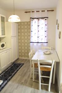 蒙特格羅托泰梅的住宿－Casa Algisa，一间配备有白色桌椅的用餐室