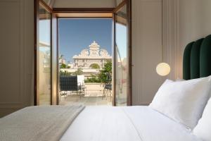 1 dormitorio con cama y vistas a un balcón en Patria Palace Lecce en Lecce