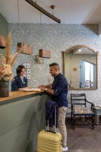 Un homme debout au comptoir avec une femme dans l'établissement Boutique Hotel Galatea, à Rome