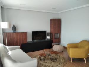 a living room with a white couch and a yellow chair at Chalet con vista a las Islas Cíes in Sanxenxo