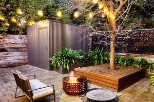 a patio with a tree and a fire pit at Adelaide Hills Escape in Woodside